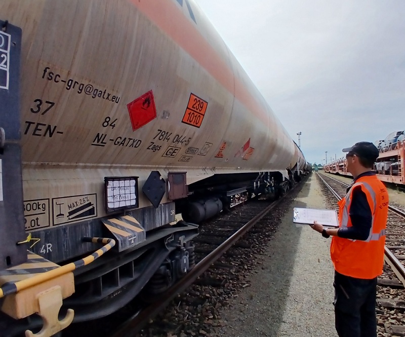 Un contrôleur des transports inspecte un wagon citerne. 